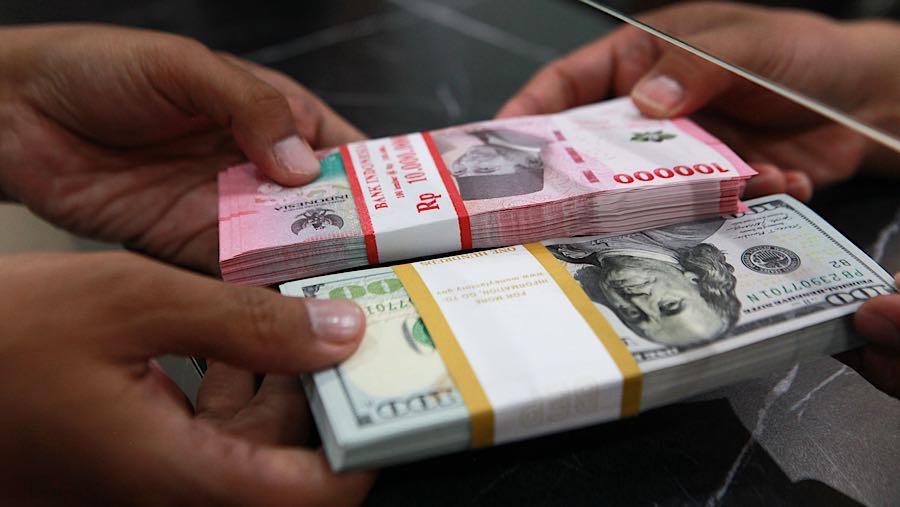 Warga menukarkan uang dolar AS ke rupiah di salah satu tempat penukaran uang di Jakarta, Jumat (9/1/2026). (Bloomberg Technoz/Andrean Kristianto)