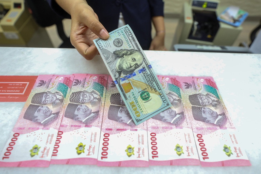 Karyawan menghitung uang dolar AS di gerai penukaran uang di Jakarta, belum lama ini./ Bisnis - Abdurachman