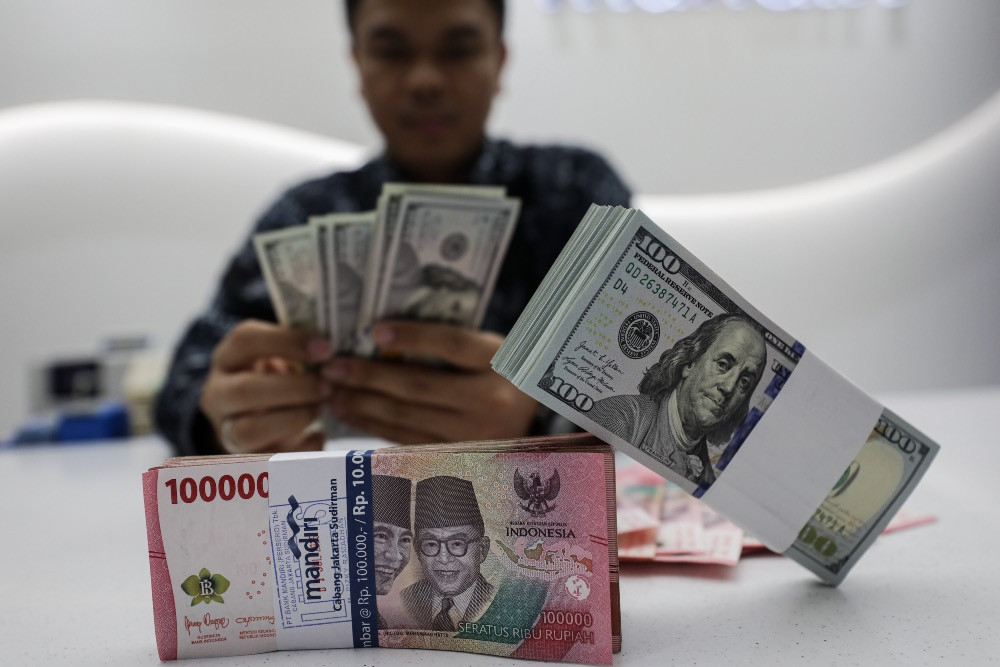 Karyawan menghitung uang dolar AS di Jakarta, Selasa (22/7/2025)./JIBI/Bisnis/Arief Hermawan P