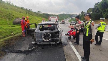 Foto: Bangkai mobil Ford EcoSport yang terbakar di Tol Semarang-Solo sedang didinginkan oleh petugas pada Sabtu (21/3/2026). (dok. Polres Semarang)