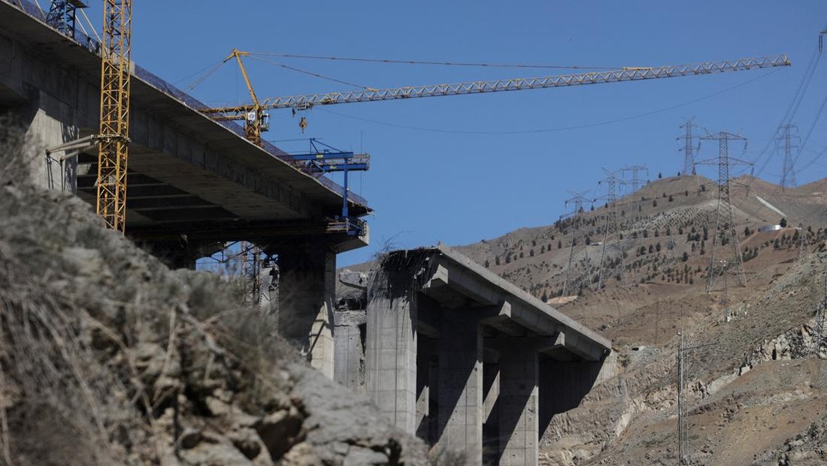 Seorang pria berdiri di dekat jembatan B1 yang rusak akibat serangan udara AS di Karaj, Iran, Jumat (3/4/2026). (Majid Asgaripour/WANA via REUTERS)