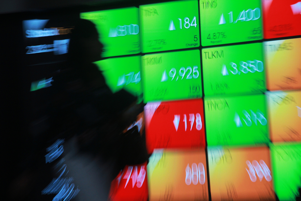 Ilustrasi seorang investor memantau pergerakan harga saham dan IHSG di layar perdagangan Bursa Efek Indonesia. (Shutterstock)
