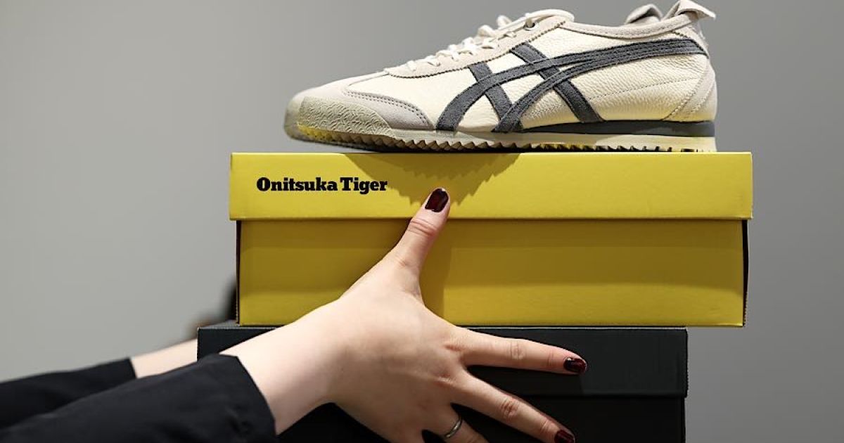 Pekerja membawa kardus dan sepatu Onitsuka Tiger di toko Onitsuka Tiger di distrik Omotesando, Tokyo, Jepang, Rabu (10/6/2026). (Foto: Kiyoshi Ota/Bloomberg)