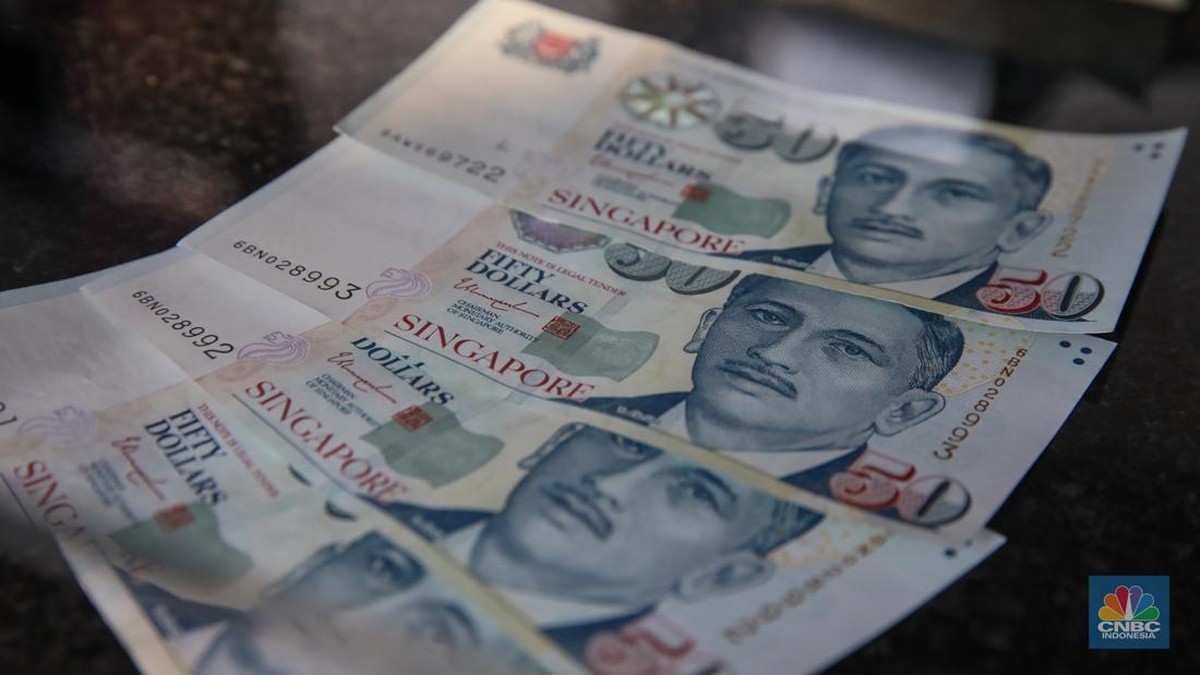Foto: Petugas menjunjukkan mata uang Dolar Singapura di VIP Money Changer, Jakarta, Kamis (25/9/2025). (CNBC Indonesia/Faisal Rahman)