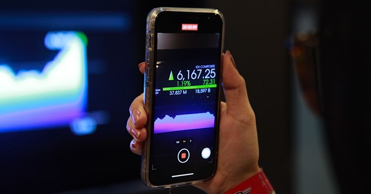 Seorang karyawan memfoto layar pergerakan harga saham (IHSG) di Bursa Efek Indonesia (BEI) beberapa waktu lalu. (Foto Bloomberg Technoz/Andrean Kristianto)
