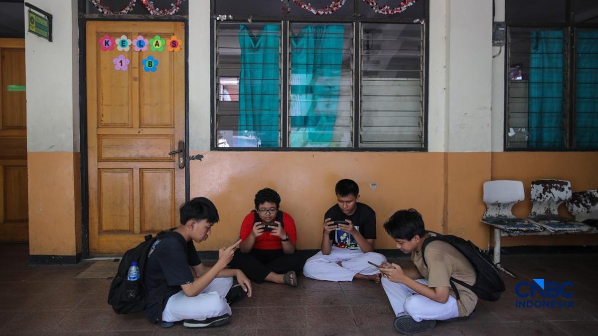Foto: Sejumlah anak memainkan ponsel mereka sesuai pulang sekolah di Jakarta, Senin (30/3/2026). Pemerintah resmi melarang anak di bawah usia 16 tahun menggunakan media sosial mulai 28 Maret 2026 berdasarkan Peraturan Menteri Komunikasi dan Digital Nomor 9 Tahun 2026, yang merupakan turunan dari PP Tunas. (CNBC Indonesia/Faisal Rahman)