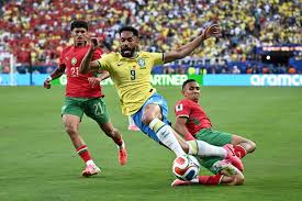Brazil's Matheus Cunha is tackled by Morocco's Ayoub Amaimouni with Anass Salah Eddine in support in their Fifa World Cup Group C game at New York/New Jersey Stadium, East Rutherford, on June 13 2026. Picture:  (Dylan Martinez/Reut)