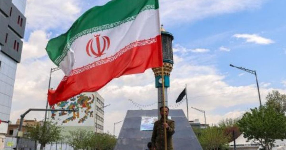 Orang memegang bendera Iran. (Foto: ATTA KENARE / AFP)