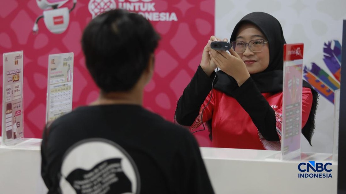 Foto: Seorang pengunjung melakukan sistem registrasi pelanggan layanan telekomunikasi berbasis data biometrik dengan dukungan teknologi pengenalan wajah di counter Smartfren, Mall Ambasador, Jakarta, Rabu, (1/7/2026). (CNBC Indonesia/Muhammad Sabki)