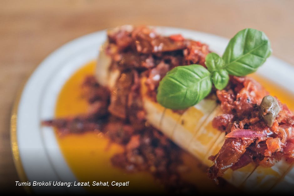 Semangkuk tumis brokoli udang yang menggugah selera dengan warna hijau cerah brokoli dan merah muda udang, disajikan dengan taburan wijen.
